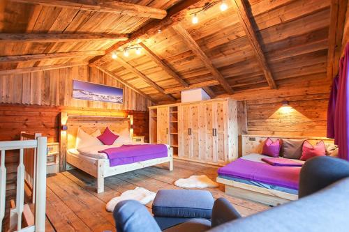 a bedroom with two beds in a log cabin at Ferienhof Pfefferbauer in Saalbach Hinterglemm