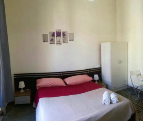 レッジョ・ディ・カラブリアにあるB&B RC DOMVSのベッドルーム1室(ピンクと白のシーツが備わるベッド1台付)