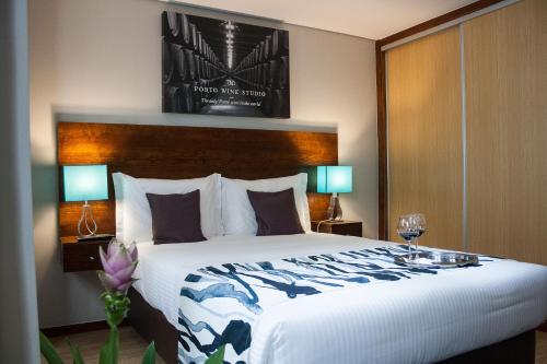 a bedroom with a large bed and two lamps at Nations Porto - Studios & Suites in Porto
