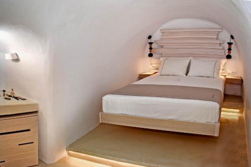 a bedroom with a bed in a white room at Aperto Suites - Adults Only in Fira