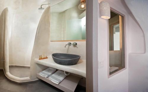 a bathroom with a sink and a mirror at Aperto Suites - Adults Only in Fira