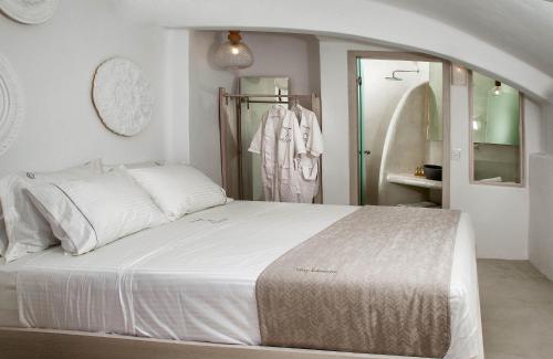 a bedroom with a large white bed and a closet at Aperto Suites - Adults Only in Fira