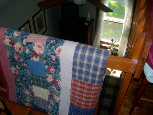 a blanket on the back of a couch with a window at Strawberry Farm B and B in Muscatine