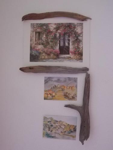three pictures hanging on a wall with a shelf at B&B Sette Fratelli in San Gregorio
