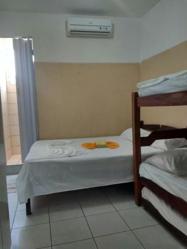 Pousada Ipojuca في كاروارو: غرفة نوم بسريرين بطابقين ومكيف