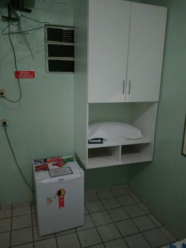 a small kitchen with a refrigerator and a cabinet at Pousada Ipojuca in Caruaru