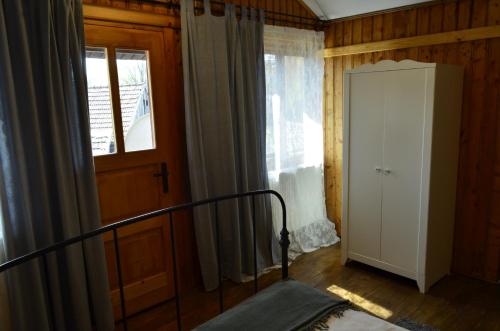 a bedroom with a bed and a window and a door at Pensiunea Deceneu in Slănic