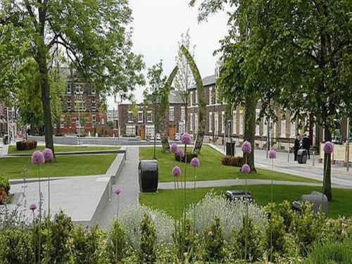 un parque con flores y árboles y un edificio en City Centre Penthouse Apartment, en Sunderland