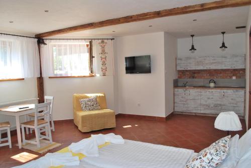 a living room with a bed and a table and a kitchen at Apartamenty Lawenda in Rabka