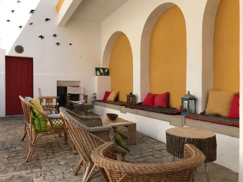 a patio with chairs and tables and a room with tables at Pátio das Andorinhas in Ferreira do Alentejo