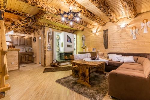 a living room with a couch and a table at Chaty Anety Domki Całoroczne in Solina
