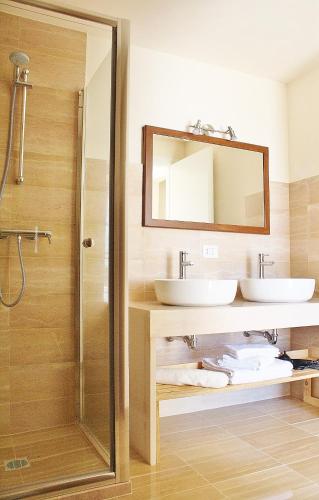 a bathroom with two sinks and a mirror at Antica Masseria Torre Mozza in Torre Santa Susanna