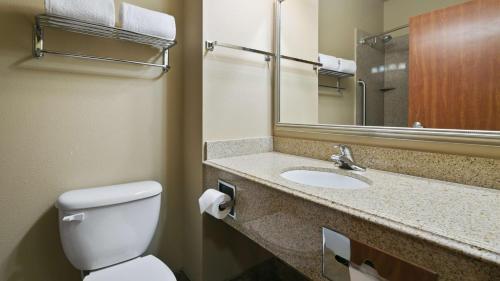 a bathroom with a toilet and a sink with a mirror at Best Western Plus Port of Camas-Washougal Convention Center in Washougal