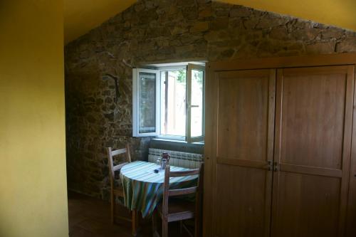 a dining room with a table and a window at Farmhouse B&B Castagnola 64 in Ne