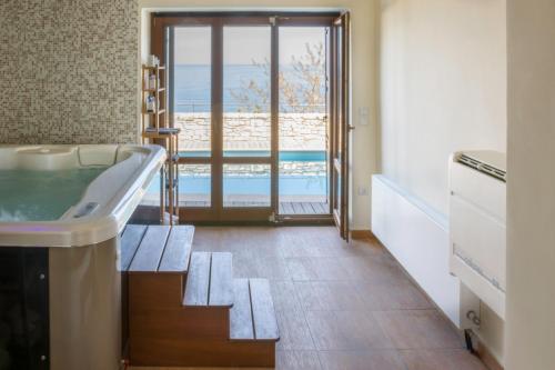 a bathroom with a tub and a pool at Dionysos Villa in Keramídhion