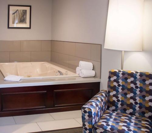 eine Badewanne in einem Zimmer mit Stuhl in der Unterkunft Best Western Toledo South Maumee in Maumee