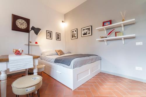Dormitorio con cama, escritorio y cama en Central Pitti Studio Flat, en Florencia