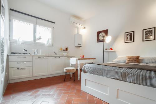 Il comprend une chambre blanche avec un lit et une cuisine. dans l'établissement Central Pitti Studio Flat, à Florence