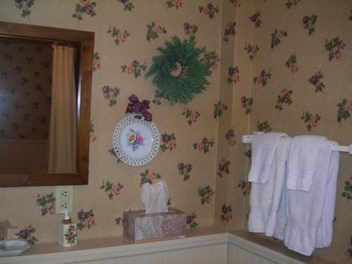 łazienka z kwiatami na ścianie i ręcznikami w obiekcie Strawberry Farm B and B w mieście Muscatine