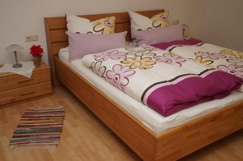 アルピルスバッハにあるFerienwohnung-Jungbauernhofのベッドルーム1室(花の咲く大型ベッド1台付)