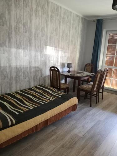 sypialnia z łóżkiem, stołem i krzesłami w obiekcie Apartament Masajka we Władysławowie