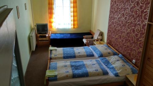 two beds in a small room with a bedroom at Hotel U Broucka in Nové Město nad Metují