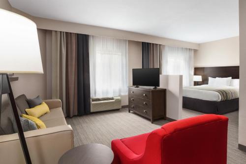 a hotel room with a bed and a tv at Country Inn & Suites by Radisson, Shreveport-Airport, LA in Shreveport