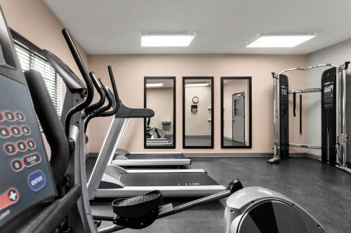 a gym with several treadmills and mirrors at Country Inn & Suites by Radisson, Shreveport-Airport, LA in Shreveport