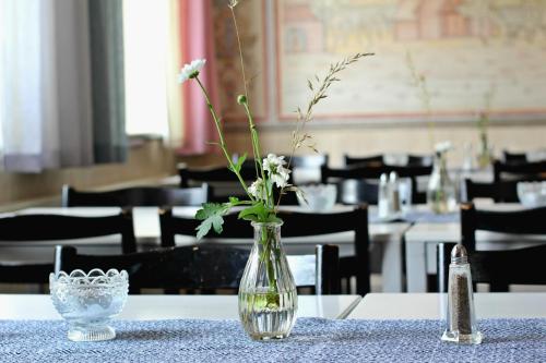 un jarrón con flores en una mesa en un restaurante en STF Sigtuna Vandrarhem, en Sigtuna