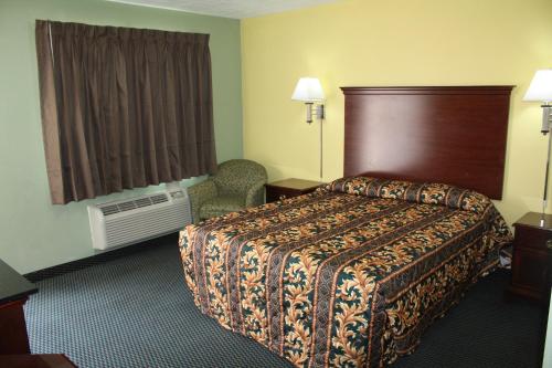 um quarto de hotel com uma cama e uma janela em Deluxe Inn Fort Stockton em Fort Stockton