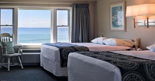 ヨーク・ビーチにあるCutty Sark Motelのベッド2台と大きな窓が備わるホテルルームです。
