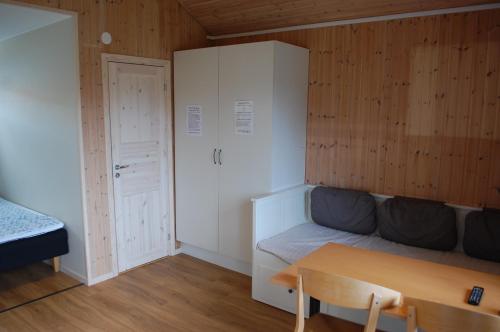 a small room with a couch and a table at Allégården Kastlösa Stugor in Mörbylånga