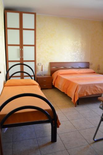 a bedroom with two beds with orange sheets at Sa Marina in La Caletta