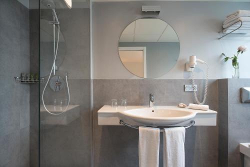 a bathroom with a sink and a shower with a mirror at La Alcoba del Agua Hotel Boutique in Sanlúcar de Barrameda