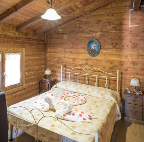 a bedroom with a bed in a log cabin at Rooms & Restaurant Il Castagneto in Campagna