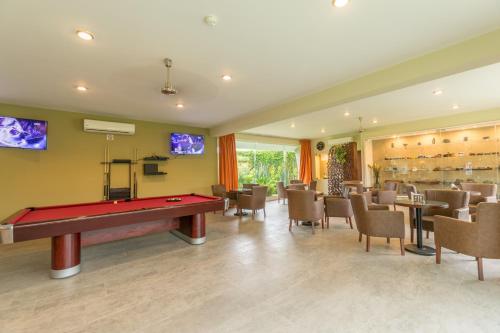 a billiard room with a pool table and chairs at Hotel Ecce Inn & Spa in Silao