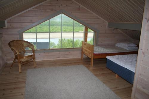 a room with a attic with a bed and a window at Arctic Aurora Borealis cottages in Nuorgam