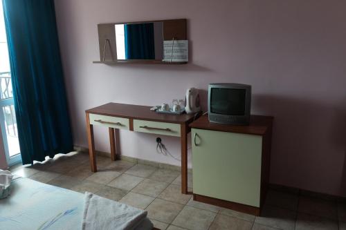 a room with a small desk with a tv on it at Sea House Guest House in Nesebar