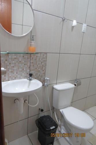 a bathroom with a toilet and a sink and a mirror at Casa Tamandaré in Tamandaré