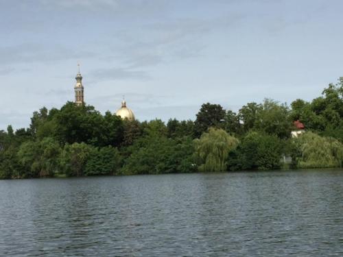 a view of a lake with a clock tower in the distance at 4 D klima in Licheń