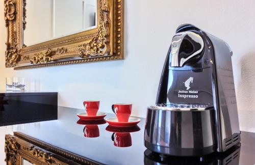 a coffee maker on a table with two red cups at Mincheta - Luxury Rooms in Primošten