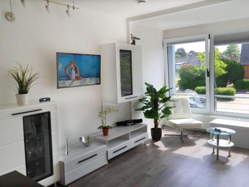 a living room with white furniture and a fireplace at Ferienwohnung-Kassiopeia-3 in Laboe