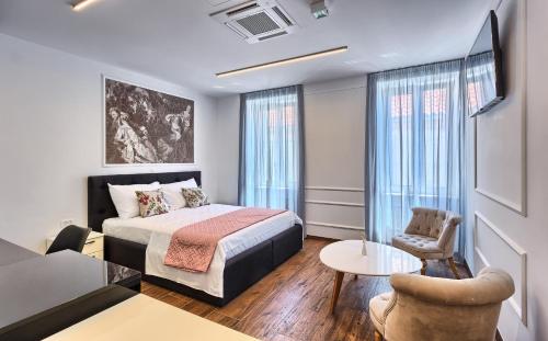 a bedroom with a bed and a living room at Mincheta - Luxury Rooms in Primo&scaron;ten