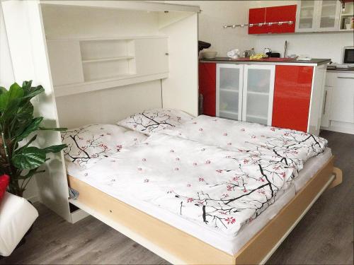 a small bed in a room with a kitchen at Ferienwohnung-Kassiopeia-3 in Laboe