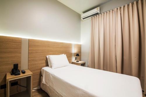 a hotel room with a bed and a window at JR Hotel in Presidente Prudente