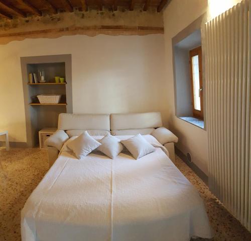 a bedroom with a large white bed with pillows at Montevenere 83 in Chiusi