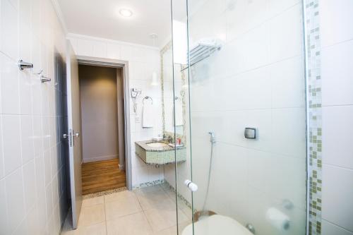 a bathroom with a shower and a toilet and a sink at JR Hotel in Presidente Prudente