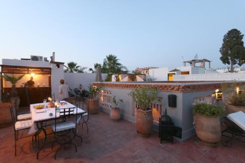 un patio con tavolo e sedie su un tetto di Riad Merstane Marrakech a Marrakech