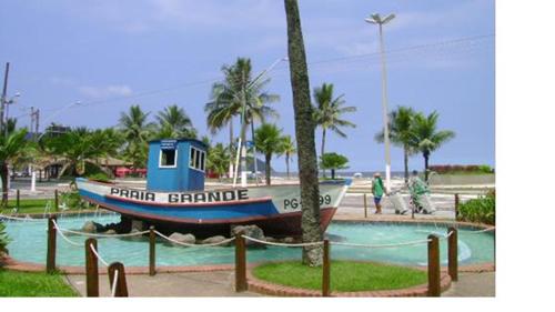 a boat sitting in the middle of a park at Casa Lado Praia Bom Espaco in Praia Grande