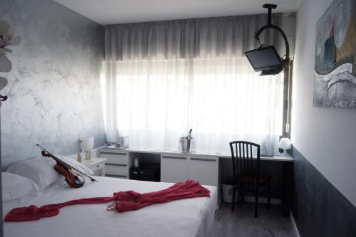 a bedroom with a bed with a violin on it at Hotel Valpolicella International in San Pietro in Cariano